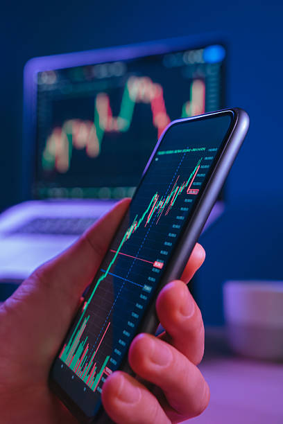 istock Man buying crypto on his smartphone at night in neon lit office 2211453322
