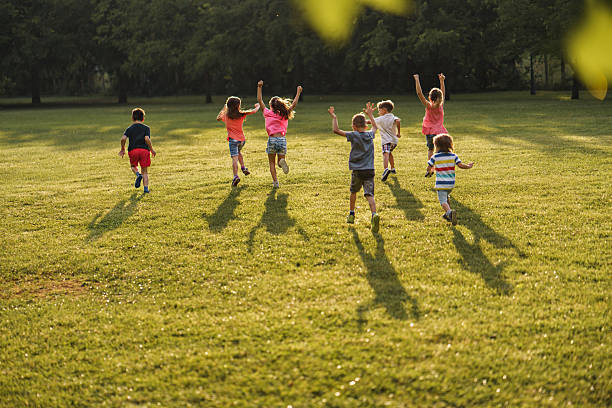 istock Children whit raised hands running in nature 2211455942