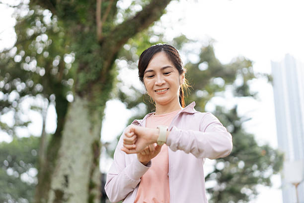 istock Cheerful Asian woman checking her physical activity on smartwatch 2211456537