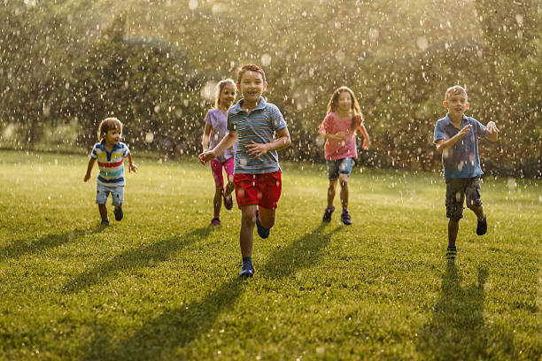 istock Children have fun during the summer rain in nature 2211456851