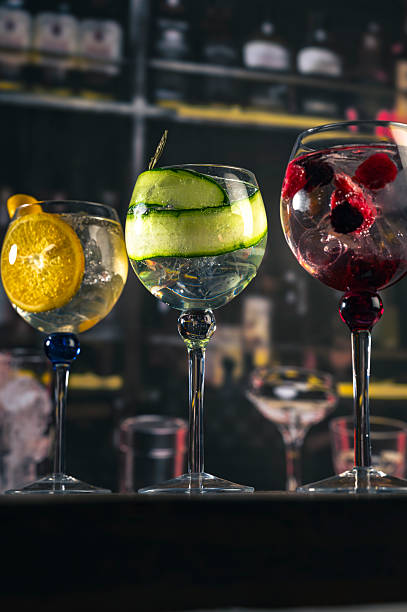 istock Three cocktails with fruit garnish on a wooden bar 2211457235