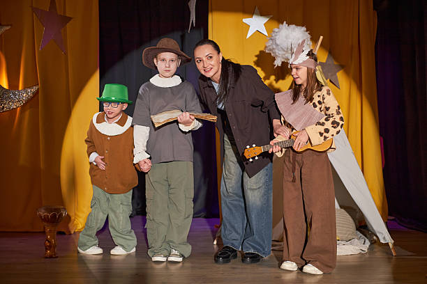 istock Children Standing with Teacher on Stage for Final Bow at Inclusive Drama School 2211457680