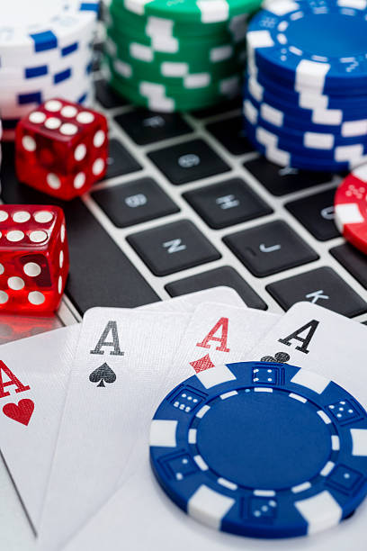 istock Gambling chips and playing card on laptop keyboard 2211458799