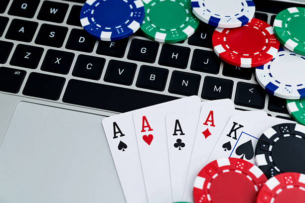 istock Gambling chips and playing card on laptop keyboard 2211460075