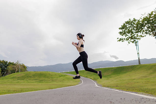 istock With focus in her eyes and strength in every stride, a young female runner charges aheaddriven to reach her goal. 2211460422