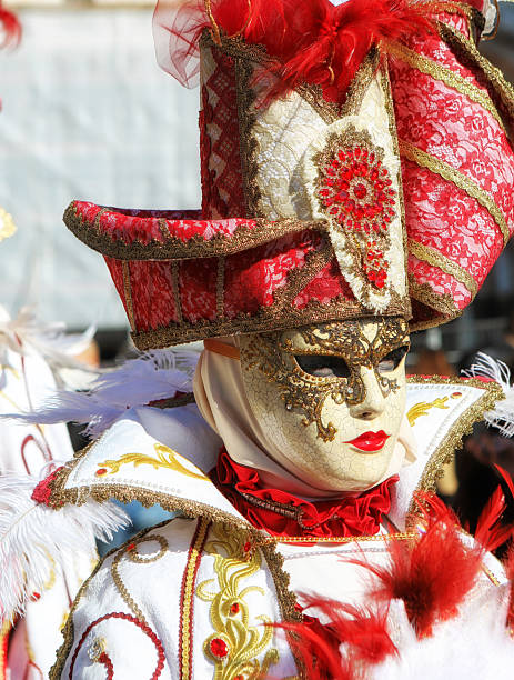 Annecy, France, February 23, 2013:Unidentified person disguised in a beautiful costume posing near the lake in Annecy, France, during a Venetian Carnival which is held yearly to celebrate the beauty of the real Venice.