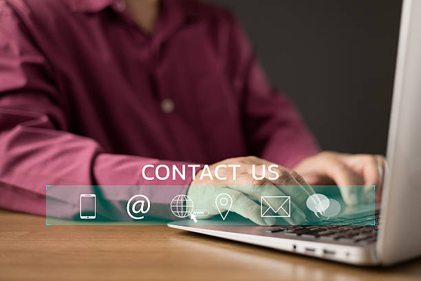 istock A man types on a laptop while a digital CONTACT US interface with icons for phone, email, web, location, and chat appears. The image represents connection, communication, and support. 2211462785