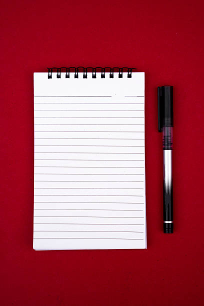 istock Minimalist Flat Lay of Open Notebook and Pen on Vibrant Red Surface 2211467569