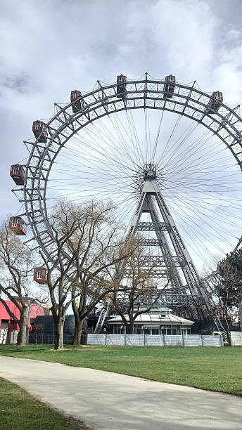 istock Giant ferris wheel with red cabins 2211468472
