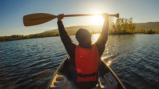 Closeup of oar paddle from row boat moving in water on green lake with ripples