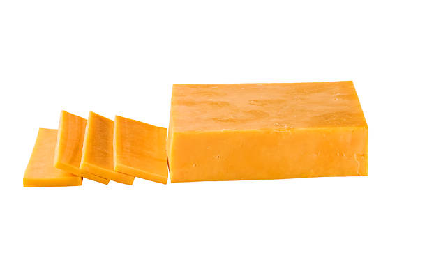 istock cheddar cheese cut into slices isolated on a white background. 2211471329