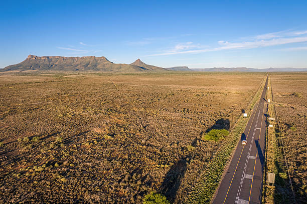 istock Long Road Through Arid Plains Leading to the Camdeboo Mountain Range 2211472487