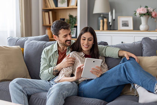 istock Couple enjoying a digital experience on sofa at home 2211472894
