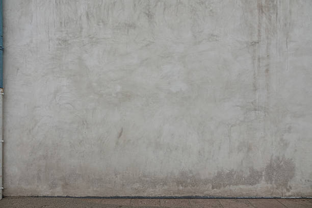 istock A simple concrete wall displays a soft texture with slight color variations. It is well-lit and provides a neutral backdrop for creative projects or design applications 2211472999