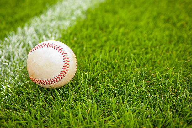 istock A baseball resting on baseball field, its white leather is slightly worn, maybe streaked with a bit of red clay or green grass 2211474372
