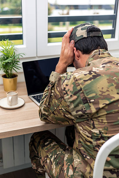 istock Soldier suffering from headache working from home in his office 2211475048