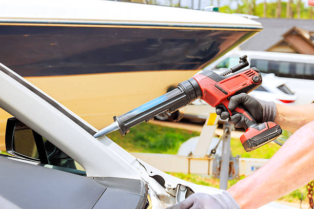 istock Repairing a vehicle using a power tool near a boat in a workshop setting on a sunny day 2211475131