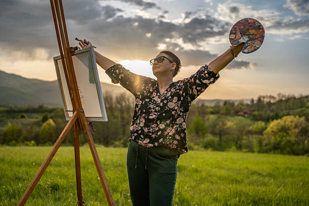 istock Artist Expresses Creativity in Open Landscape with Vibrant Colors at Sunset 2211476122