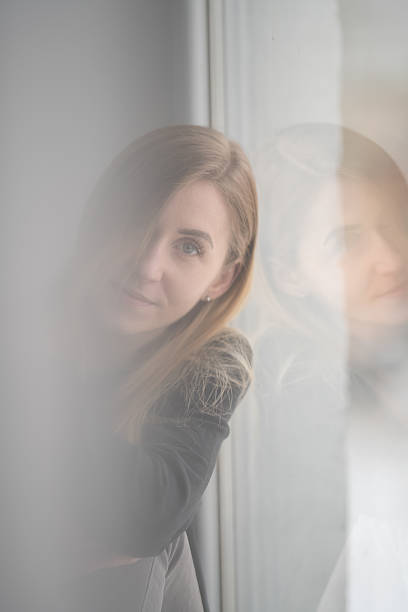 istock Peaceful Young Woman Looking Through Bright Window 2211478474