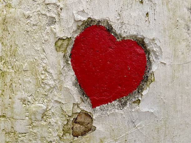 istock Red heart engraved and painted on old wall. 2211483960