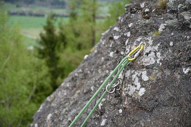 istock Climbing Rope Secured on Rocky Cliff with Scenic Spring Landscape in Background 2211486841