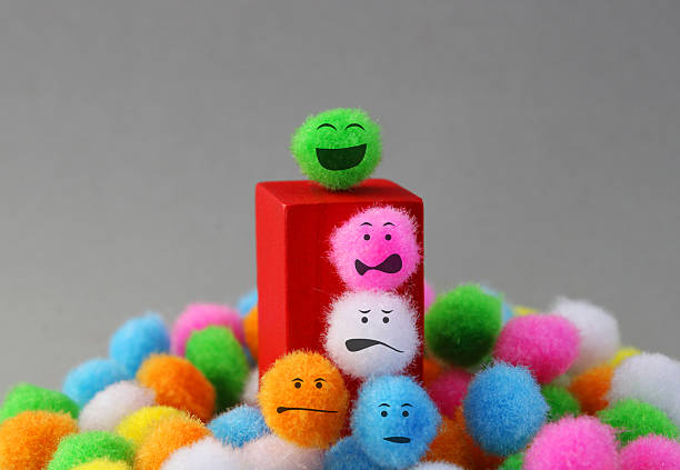 Plush spheres with different expressions trying to reach the leader