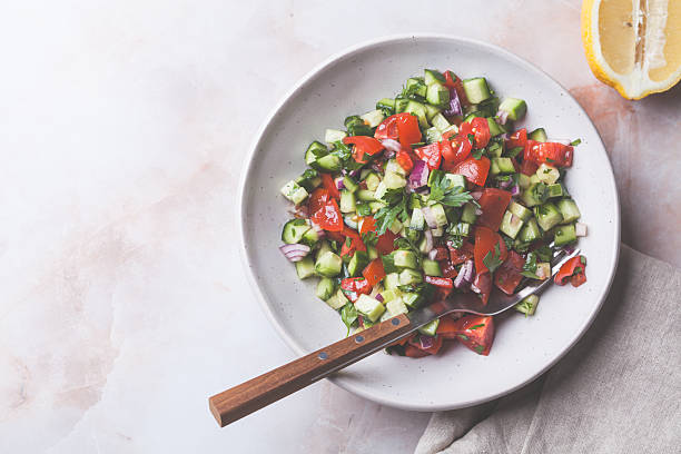 istock Vegetable salad with tomatoes, cucumbers, onions and parsley. 2211490374