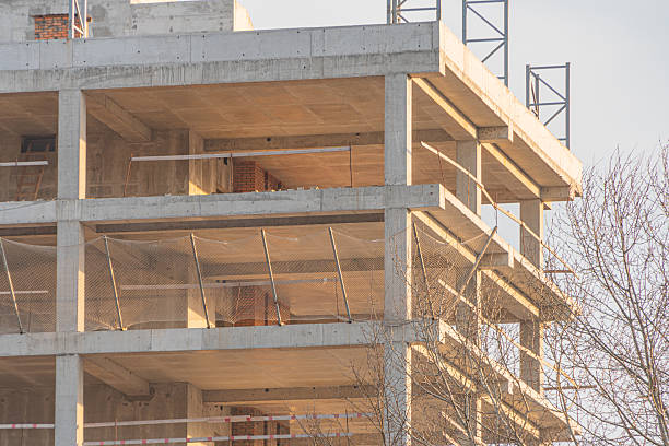 istock A mid-construction building skeleton under overcast skies, with trees in the background 2211490728