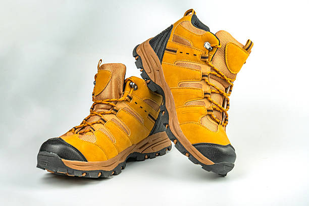 istock Image shows bright mustard hiking shoes with sturdy laces and robust soles, highlighted against a neutral background for outdoor apparel marketing 2211490742
