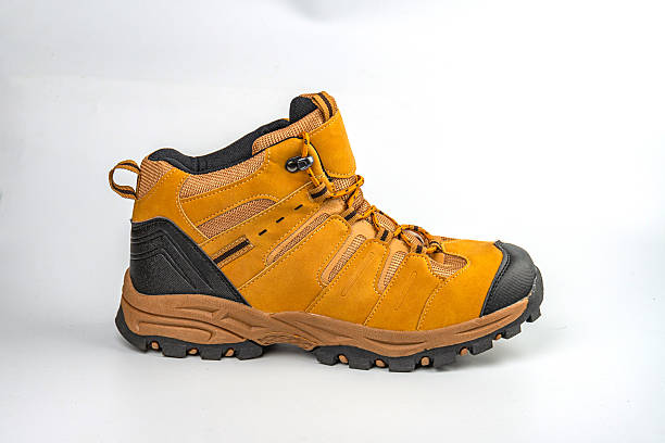istock A sturdy hiking boot with deep treads, neutral coloration brown, straps and buckles for secure fastening, showcased against a plain background 2211490919