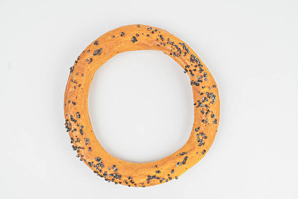 A ring-shaped, textured donut with seeds, set against a plain background Highlights artisanal quality