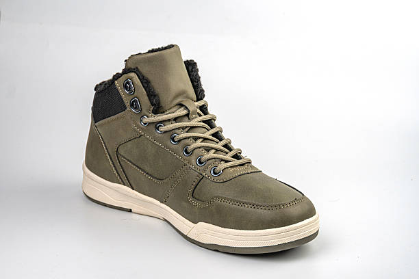 istock Image displays a high-top sneaker with an olive green upper, black toe box, and white sole with a unique tread pattern The midsole is cushioned for comfort 2211491442