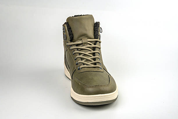 istock Image shows an olive green high-top boot with white laces on a gray background, suggesting durability and comfort 2211491455