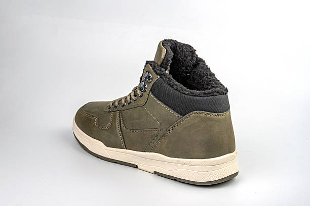 istock Image showcases a single rugged, dark greenolive suede boot with white stitching and laces, gray midsole, and no visible branding Professional product photo style for online retail or promotions 2211491543