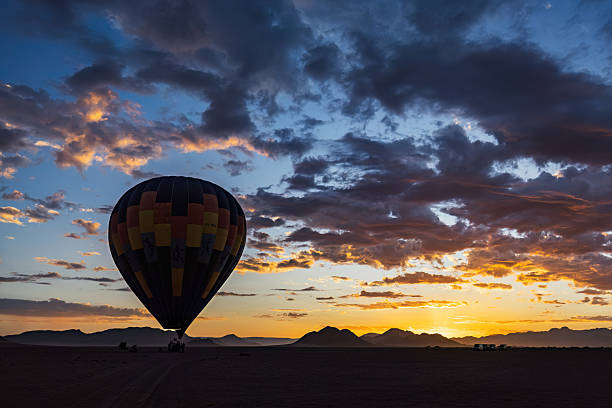 istock Hot air balloon silhouetted at sunrise in Namibia 2211492425