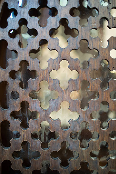 This closeup image shows a beautifully carved wooden surface with a strikingly unique pattern of cutout shapes