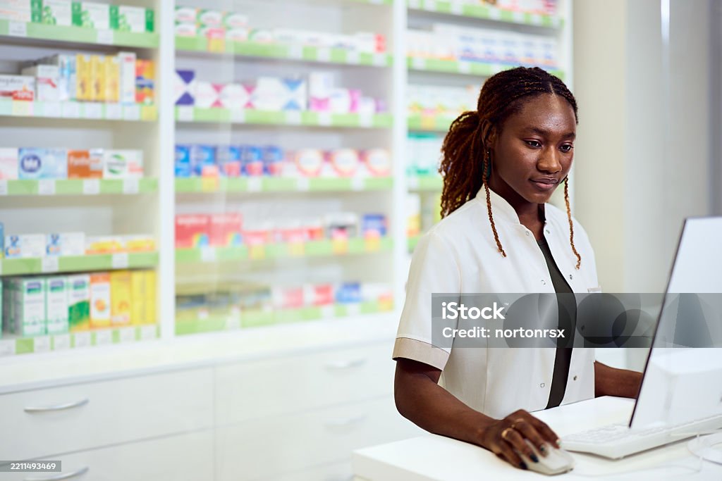 Pharmacist Using A Computer Pharmacist Working At A Computer In A Professional Pharmacy Setting ...