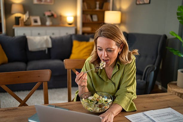istock Businesswoman eating salad while working from home 2211497503