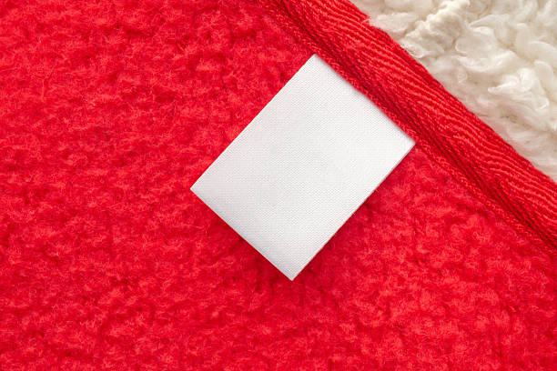 istock Blank white laundry care clothes label on red shirt fabric texture background 2211508223