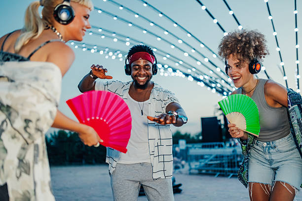 istock Young people dancing at silent disco with hand fans 2211508367