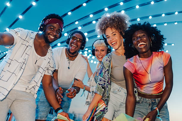 istock Young people wearing headphones smiling at silent disco 2211508394