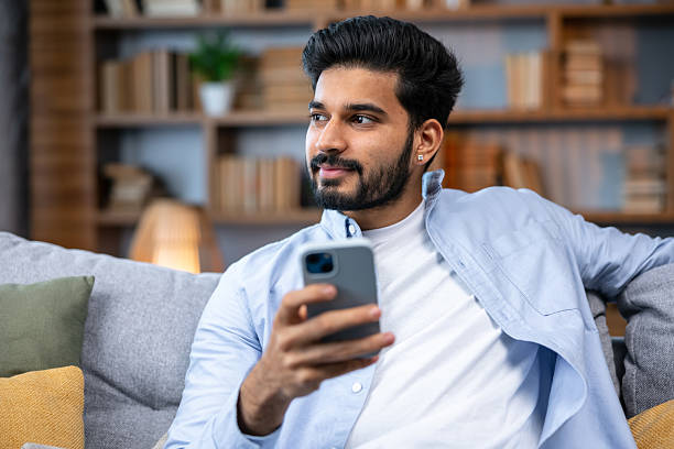 istock Young man working at home using laptop and smartphone thinking looking aside 2211510223