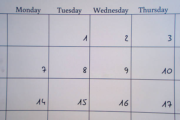 Blue tinted image of stacked calendars with light rays.