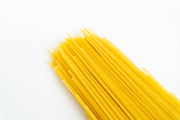 istock A bundle of uncooked spaghetti pasta in white background. 2211517657