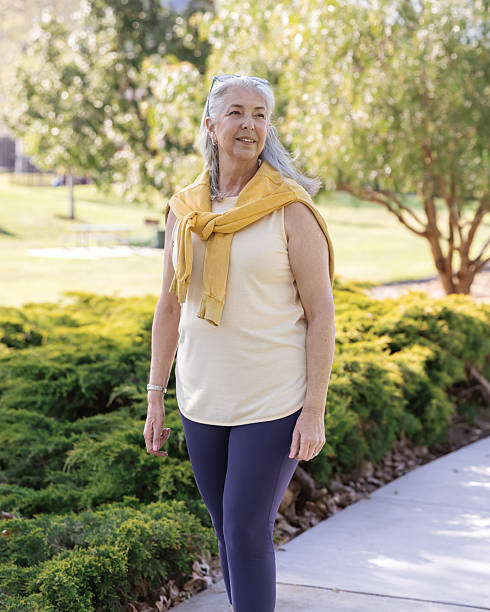 istock Athletic senior woman walking in a park 2211518316