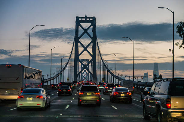Vehicles moving along Oakland Bay Bridge as daylight fades into evening sky