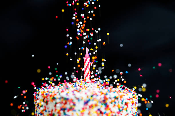 Candy beads dropping on cake with a candle