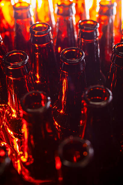 istock Dark amber beer bottles with light shining through 2211521313