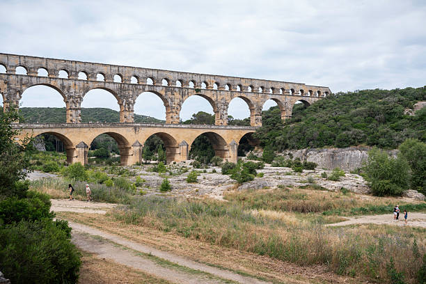 Pont du Gard, France - June 18, 2024: Tourists visit the ancient Roman aqueduct built in 1AD, which carried water 31 miles to Nimes, Provence