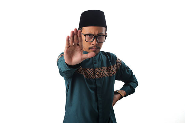 istock Confident Asian Muslim Man Showing Stop Gesture in Warning 2211526741
